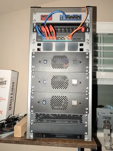 Oct 2026. The mini rack today: the retired SG-1000 and a 5-port switch, a 2.5 Gb PoE switch with 10 Gb uplinks, a JetKVM per node, and three Ryzen 9 nodes.